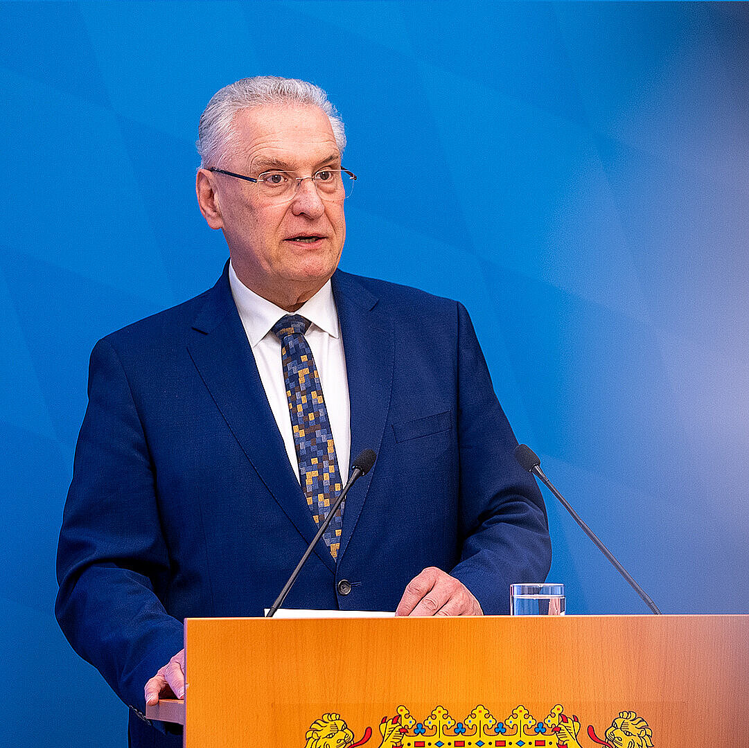 Innenminister Joachim Herrmann ernst blickend am Rednerpult