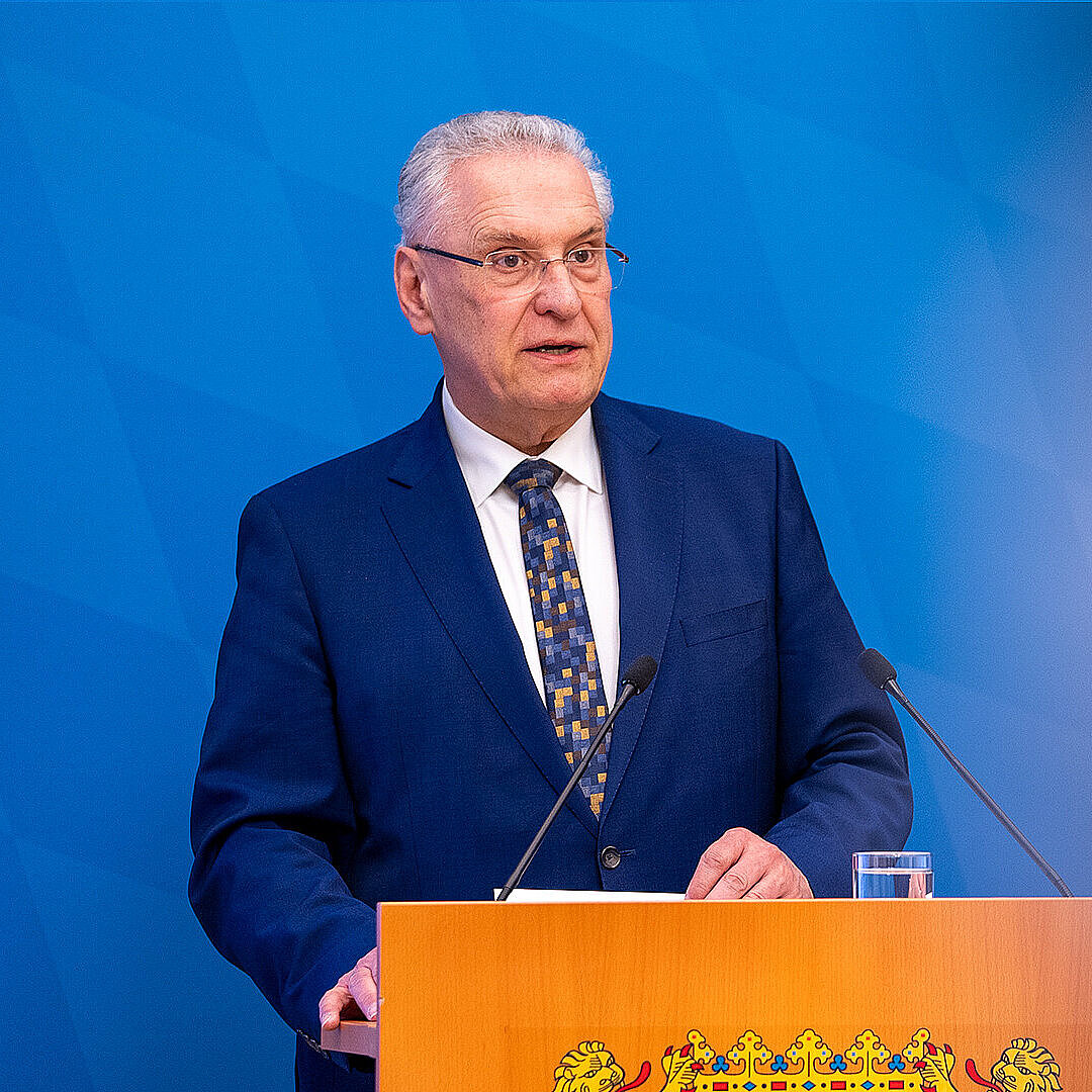 Innenminister Joachim Herrmann ernst blickend am Rednerpult