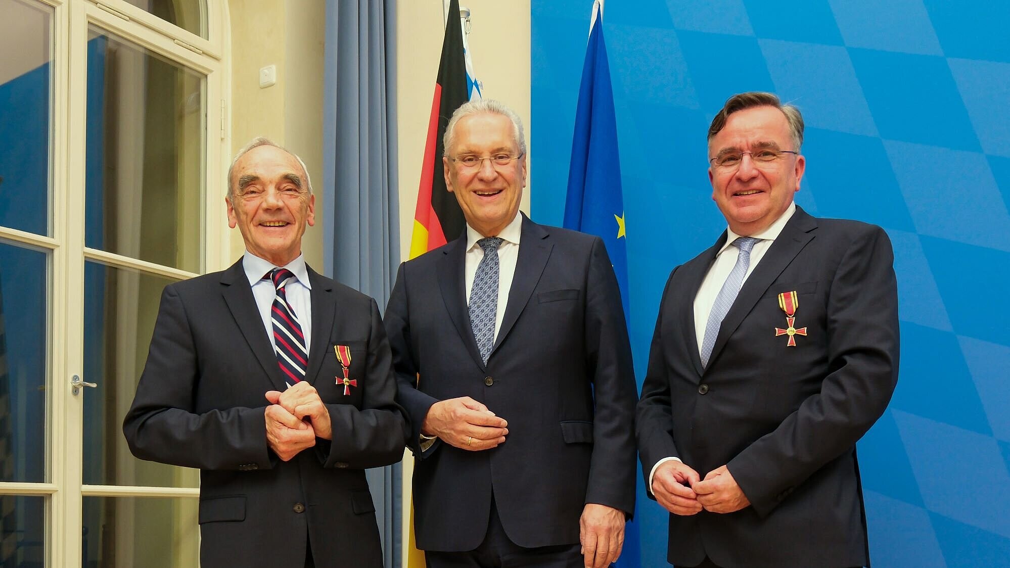 Auf dem Bild sind Innenminister Joachim Herrmann und die beiden mit dem Bundesverdienstorden ausgezeichneten Johann (Hans) Reichhart und Dr. Michael Bayeff-Filloff zu sehen.
