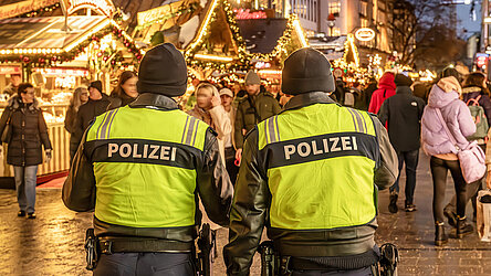 Polizeistreife auf dem Christkindlmarkt am Marienplatz und Kaufingerstraße, Polizisten zeigen Präsenz, uniformierte Streifen verbessern die Sicherheit, zeigen Wachsamkeit, weihnachtlich dekorierten Fußgängerzone, festlicher Lichterglanz, Geschäfte