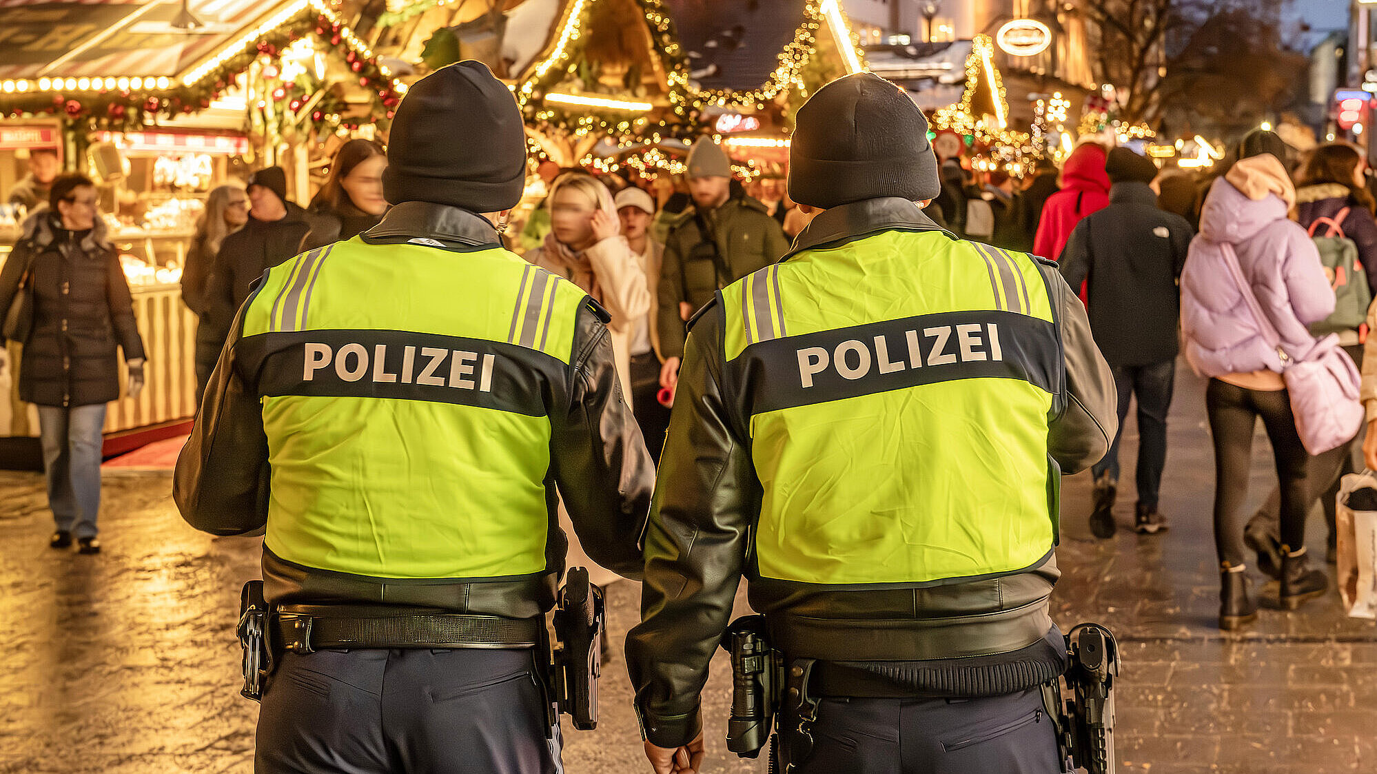 Polizeistreife auf dem Christkindlmarkt am Marienplatz und Kaufingerstraße, Polizisten zeigen Präsenz, uniformierte Streifen verbessern die Sicherheit, zeigen Wachsamkeit, weihnachtlich dekorierten Fußgängerzone, festlicher Lichterglanz, Geschäfte