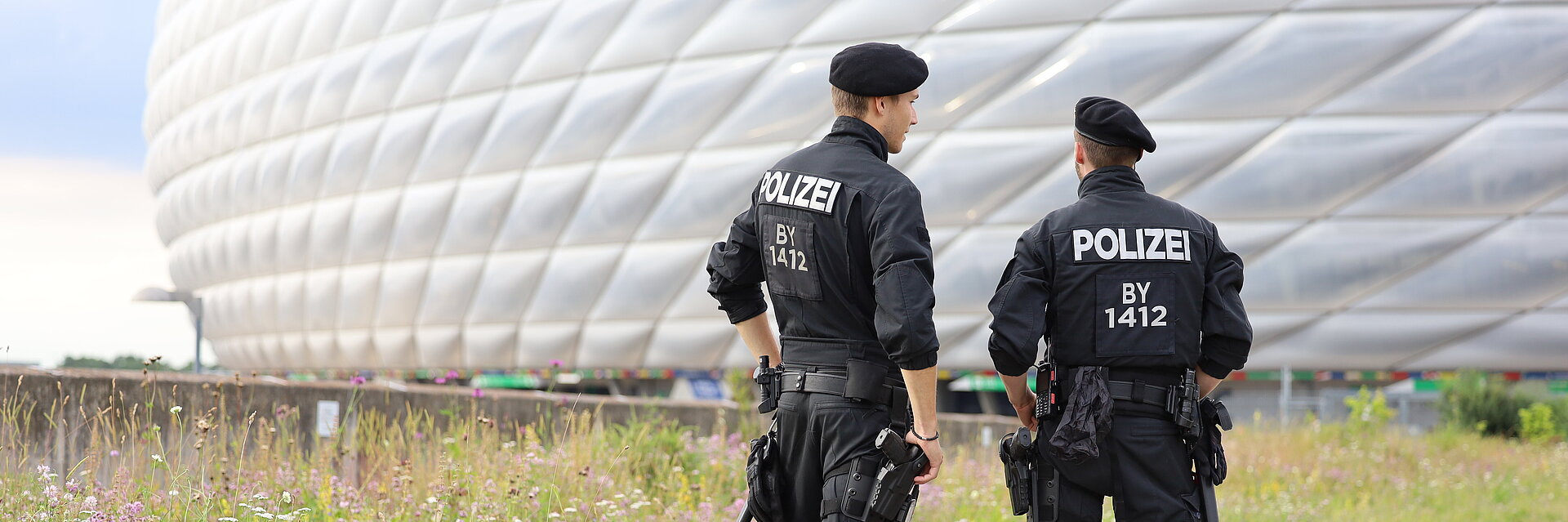zwei Polizeibeamte von hinten stehend vor der Allianzarena