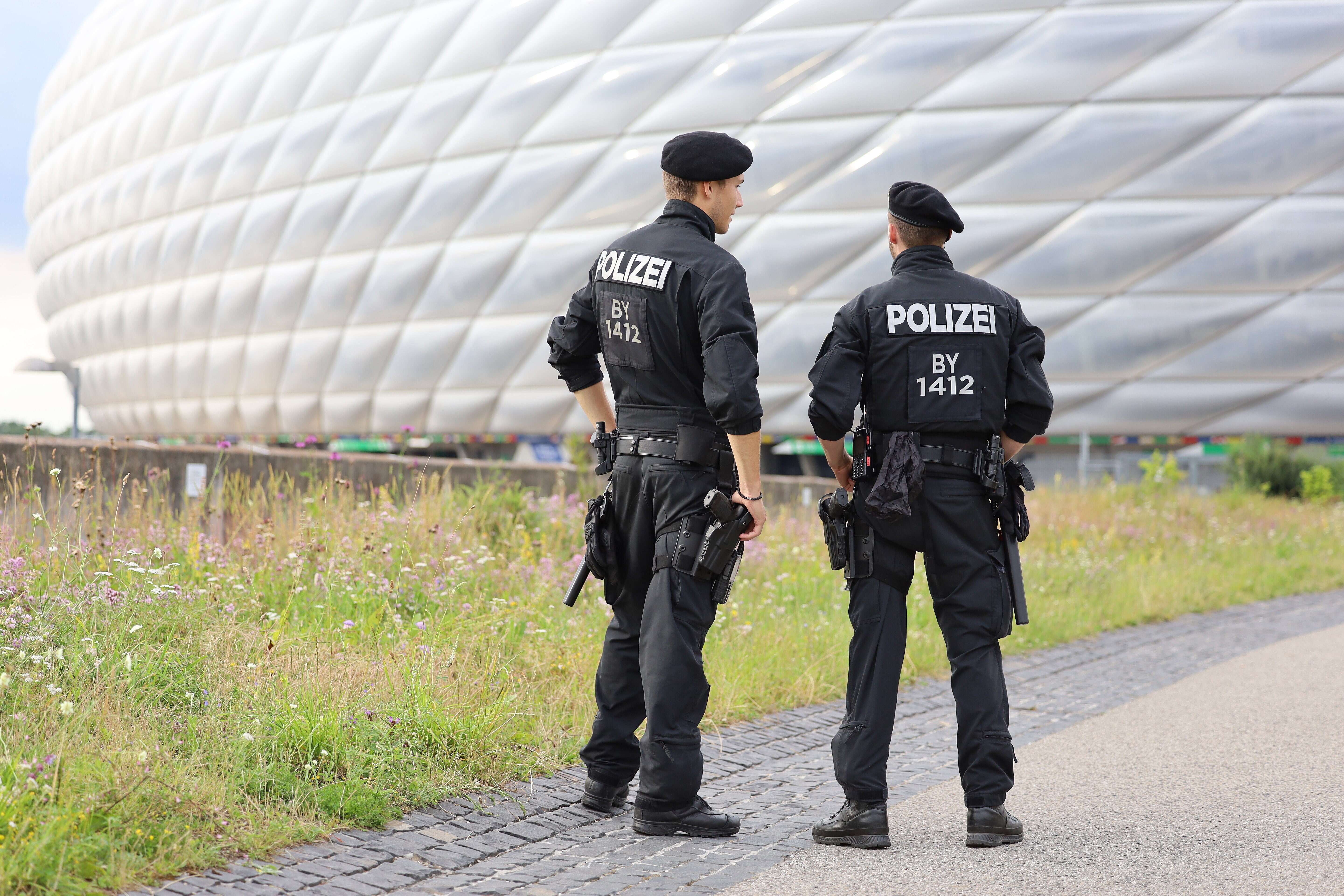 zwei Polizeibeamte von hinten stehend vor der Allianzarena