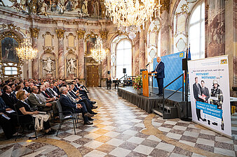 Prunkvoller Festsaal im Schloss Würzburg mit Publikum und Festredner am Rednerpult, Innenminister Herrmann