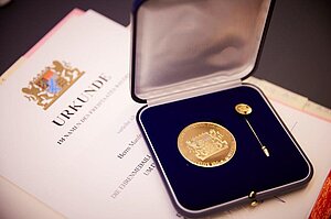 Ehrenmedaille Sport im blauen Samtetui liegend auf der Ehrenurkunde