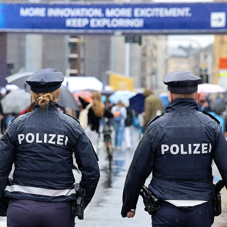 Auf dem Bild sind zwei Polizisten zu sehen, während ihrer Streife bei der IAA. Um sie herum viele Besucherinnen und Besucher