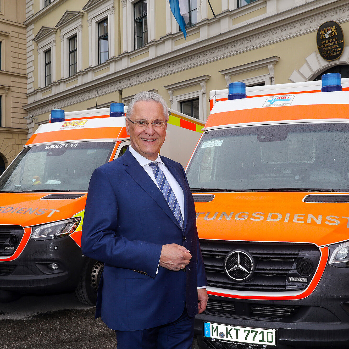 Innenminister Joachim Herrmann vor Rettungsdienst-Fahrzeugen vor dem Innenministerium