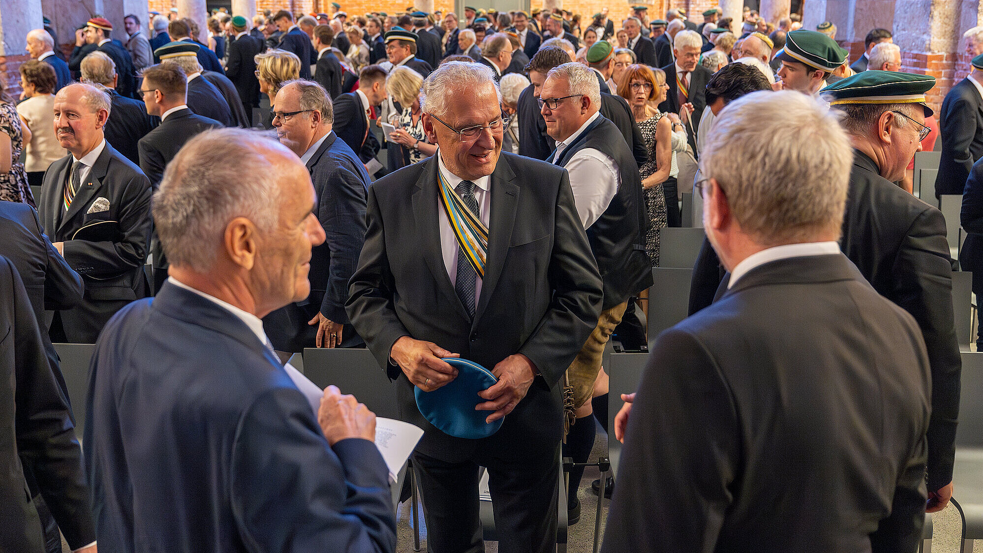 Menschenmenge in Allerheiligen-Hofkirche, im Vordergrund mehrere Personen in einer Unterhaltung vertieft