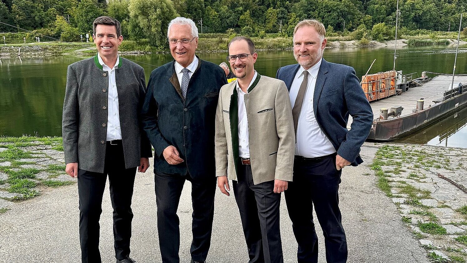 Innenminister Herrmann mit Honoratioren der Gemeinde Sinzing vor einem Fluss