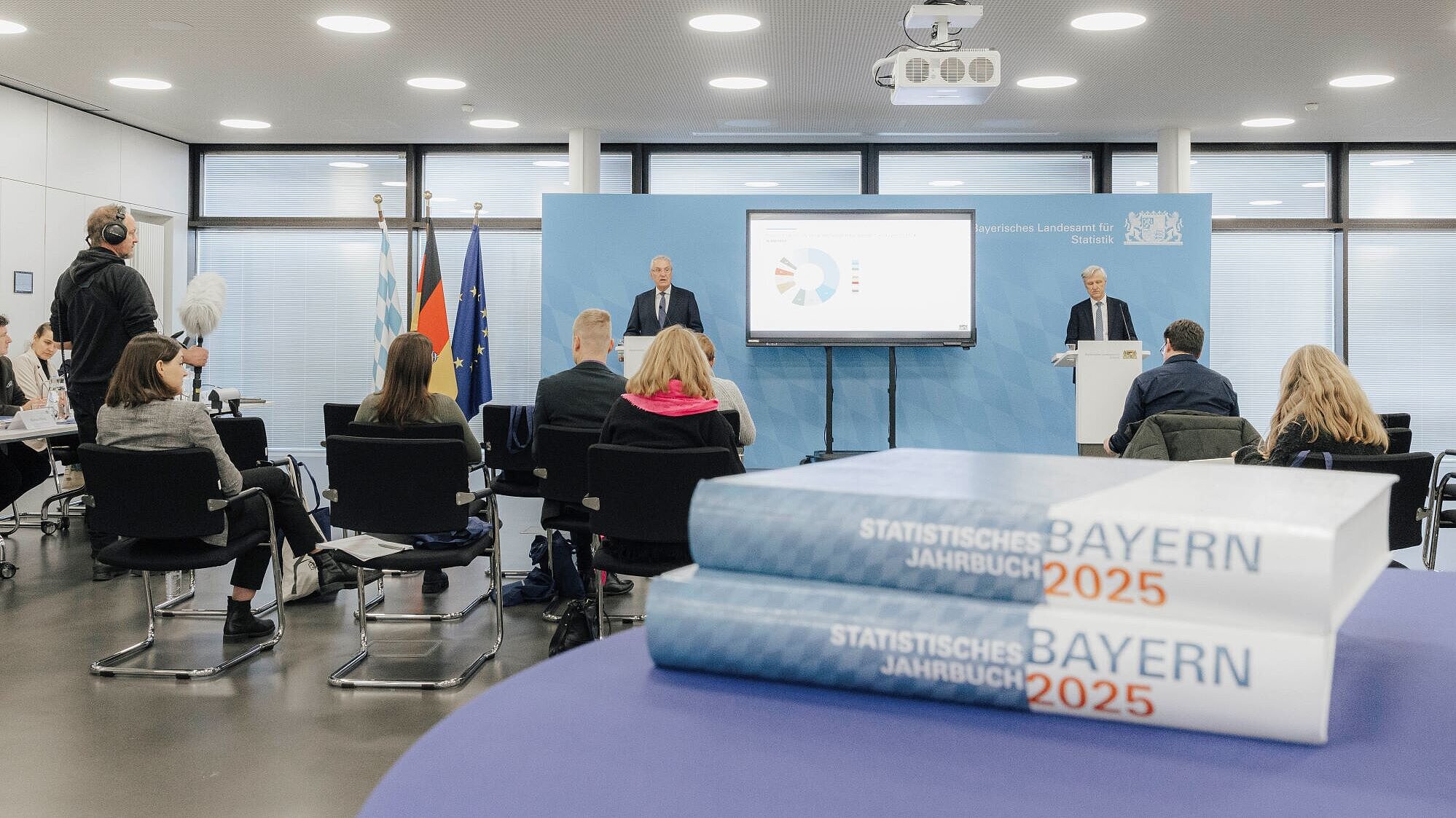 Bild auf die PK von Innenminister Herrmann und Präsident Dr. Gössl, im Vordergrund zwei Jahrbücher.