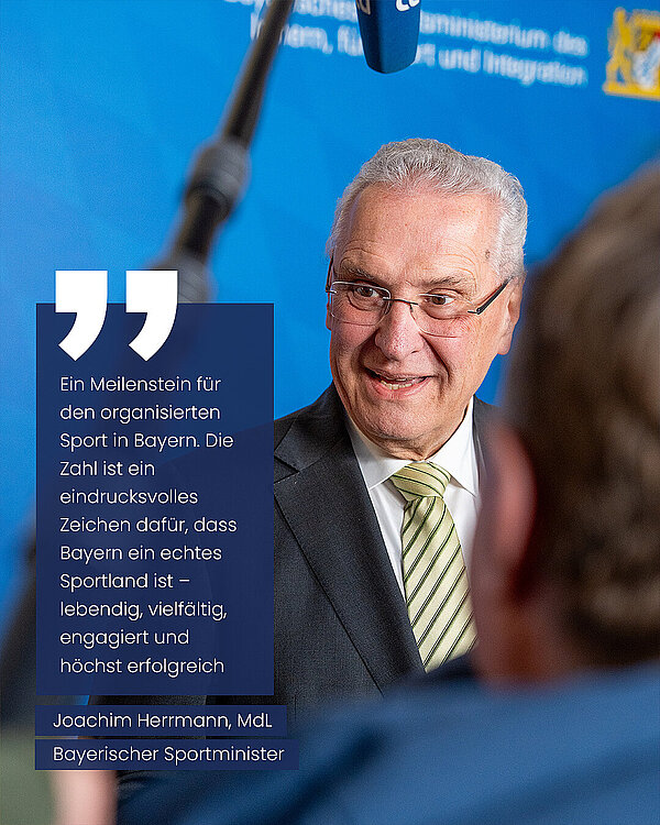 Nahaufnahme von Innenminister Joachim Herrmann im Interview vor Pressevertretern. Zitat Herrmann: "Ein Meilenstein für den organisierten Sport in Bayern. Die Zahl ist ein eindrucksvolles Zeichen dafür, dass Bayern ein echtes Sportland ist - lebendig, vielfältig, engagiert und höchst erfolgreich." Joachim Herrmann, MdL, Bayerischer Sportminister