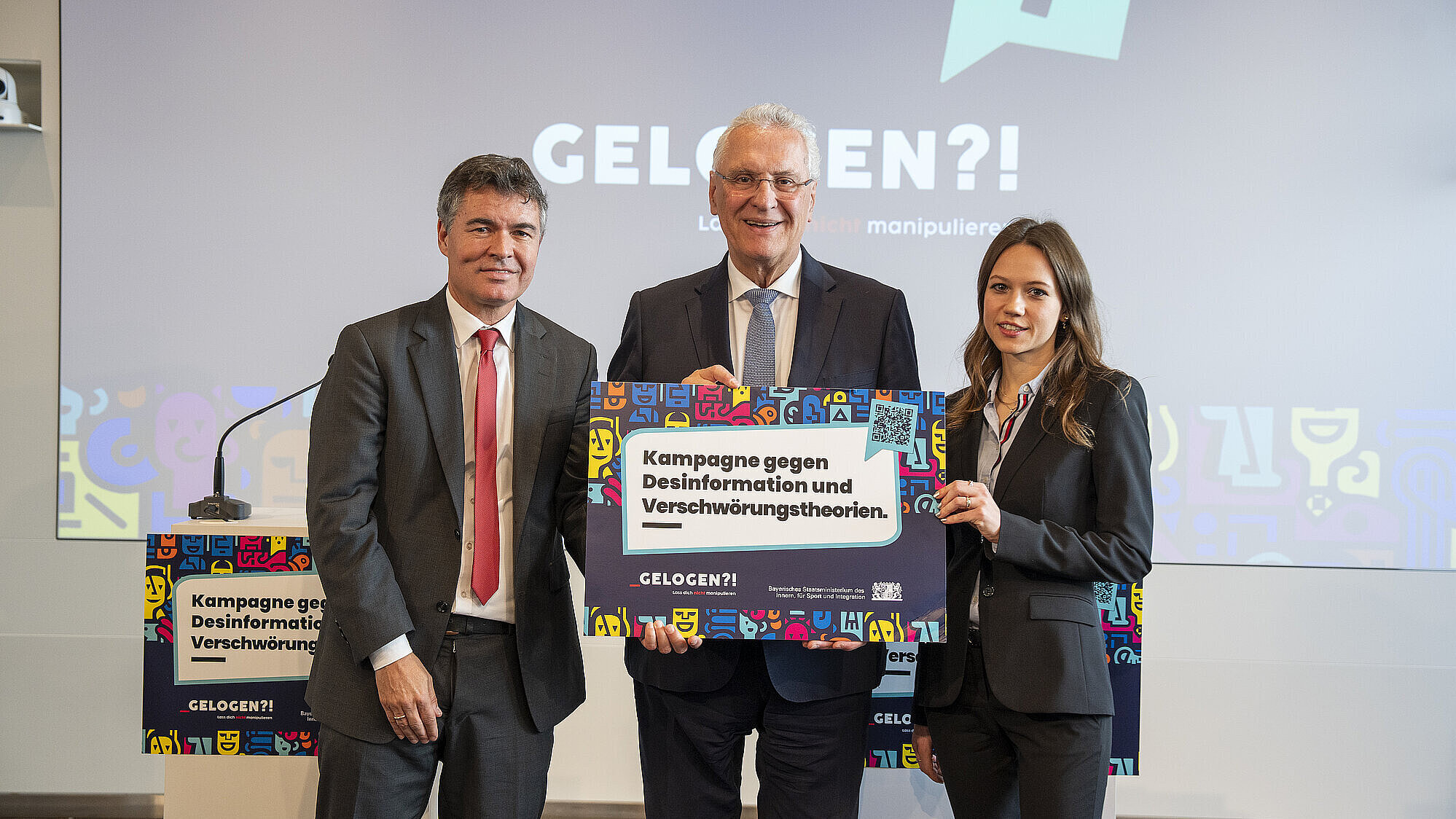 Innenminister Joachim Herrmann mit Prof. Dr. Alicia von Schenk und Manfred Hauser, Präsident des Bayerischen Landesamtes für Verfassungsschutz, und einem Plakat zur Kampagne vor Präsentation