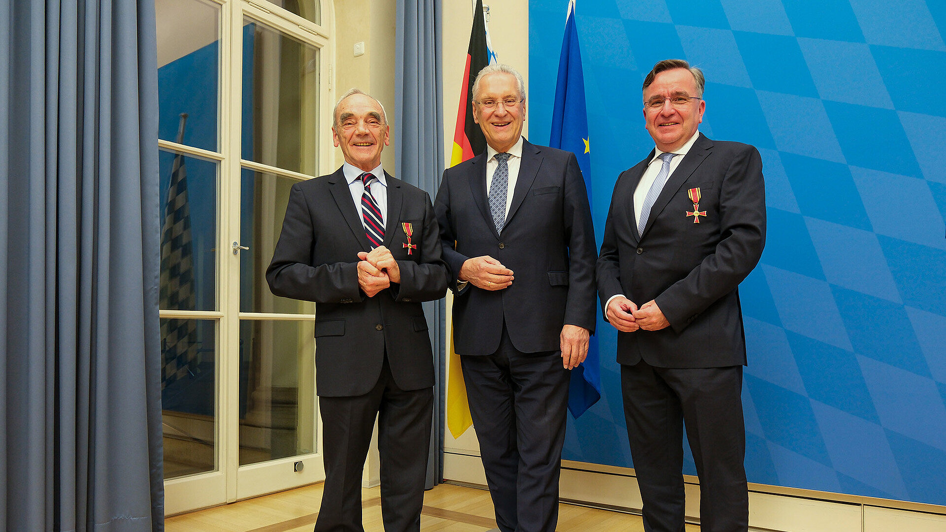 Minister Herrmann mit Herrn Johann (Hans) Reichart und Dr. Michael Bayeff-Filoff vor einem Fahnenset