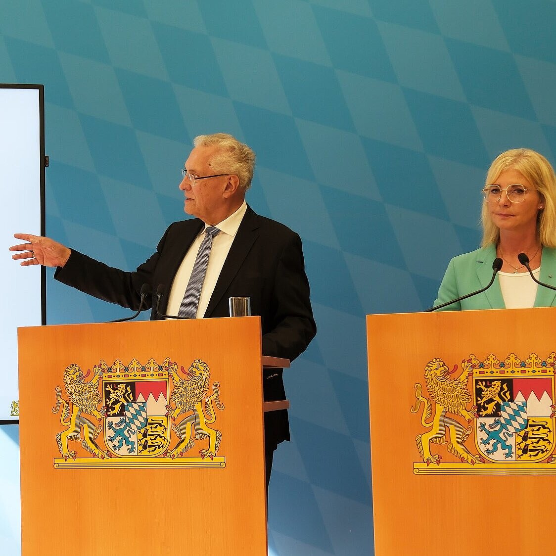 Auf dem Bild sieht man Innenminister Joachim Herrmann, wie dieser anhand einer Power-Point-Präsentation Fakten zur Arbeitsmarktintegration erläutert.
