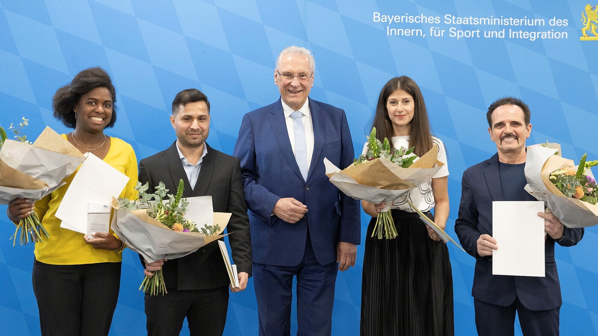 Herrmann zwischen vier Eingebürgerten mit Blumensträußen