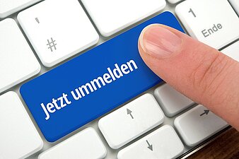 Eine Tastatur mit einer blauen Enter-Taste auf der steht "jetzt ummelden"