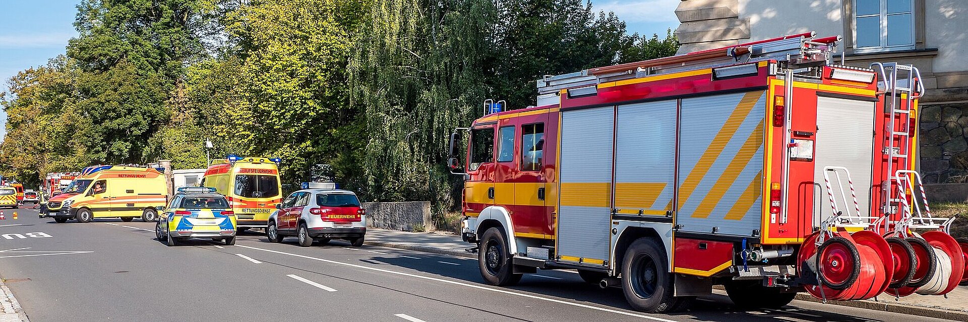 Polizei-, Feuerwehr- und Notarztautos stehen auf einer Straße