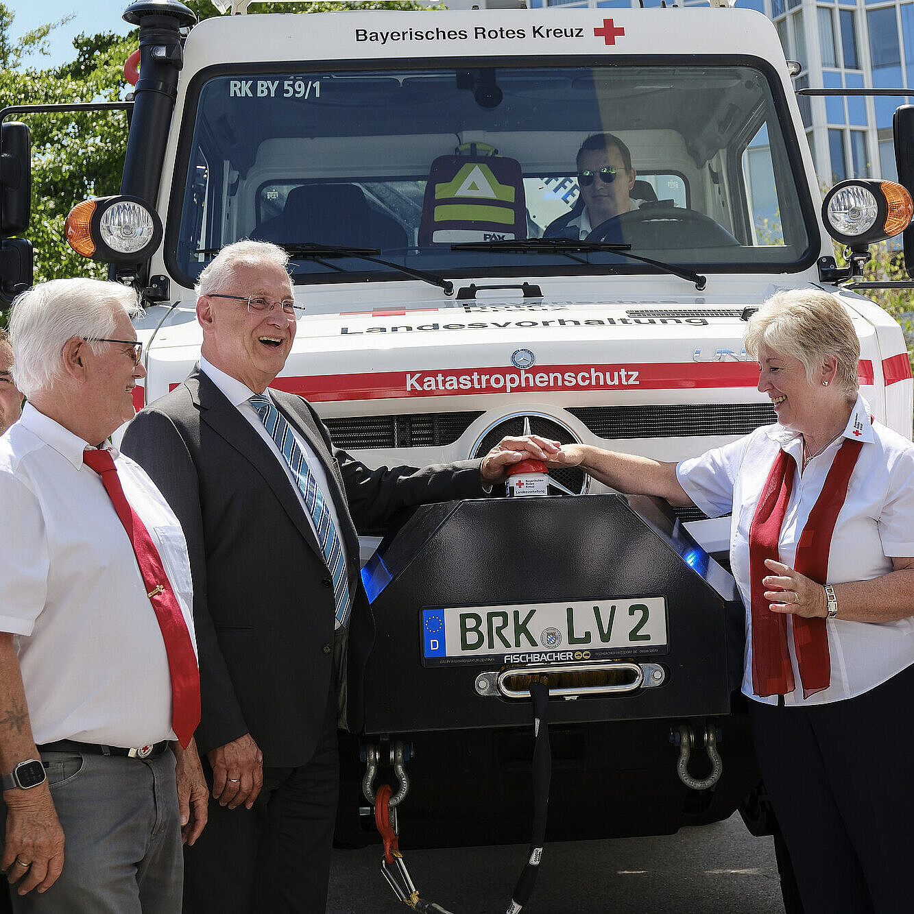 Innenminister Herrmann mit Vertretern des Bayerischen Roten Kreuzes (BRK) neben großem Katastrophenschutzwagen vom BRK