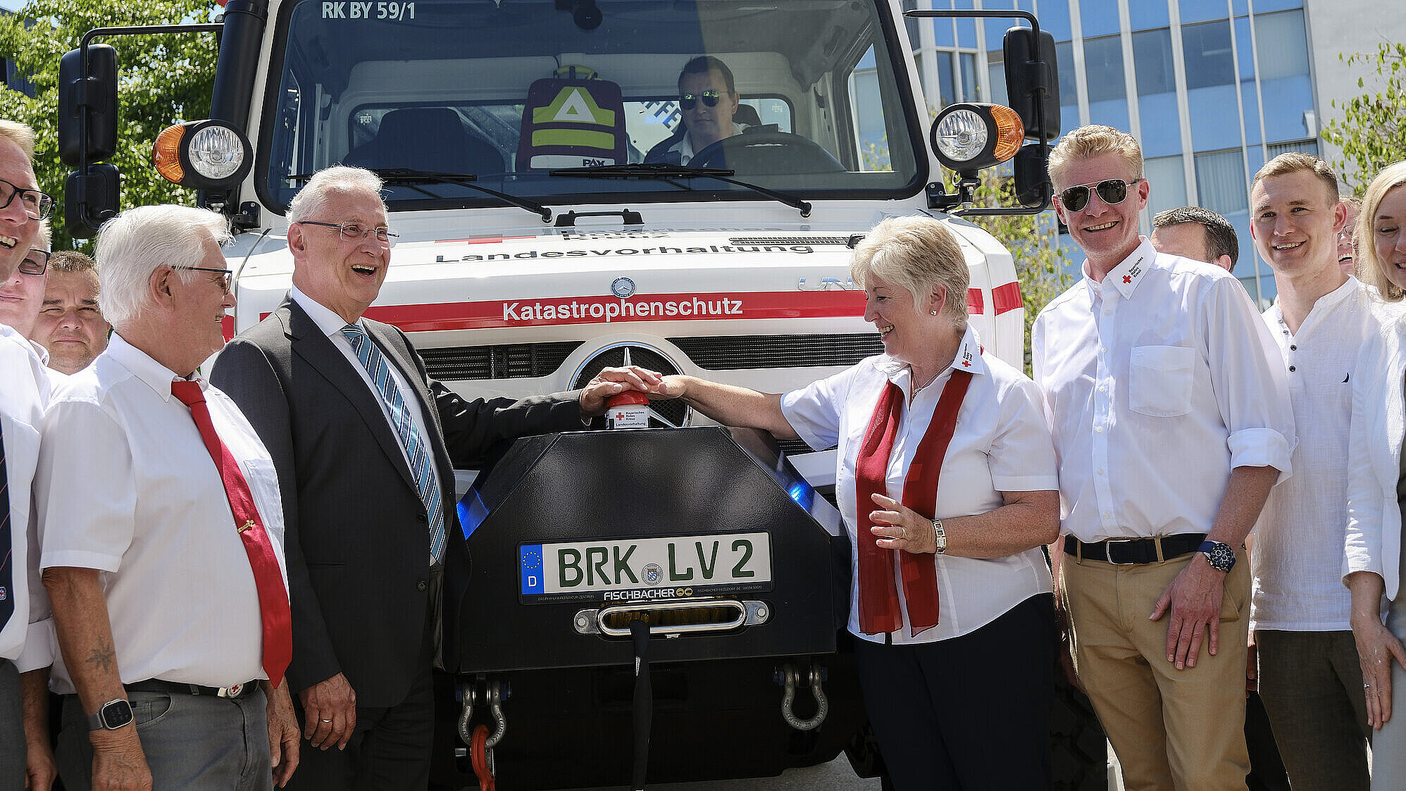 Innenminister Herrmann mit Vertretern des Bayerischen Roten Kreuzes (BRK) neben großem Katastrophenschutzwagen vom BRK