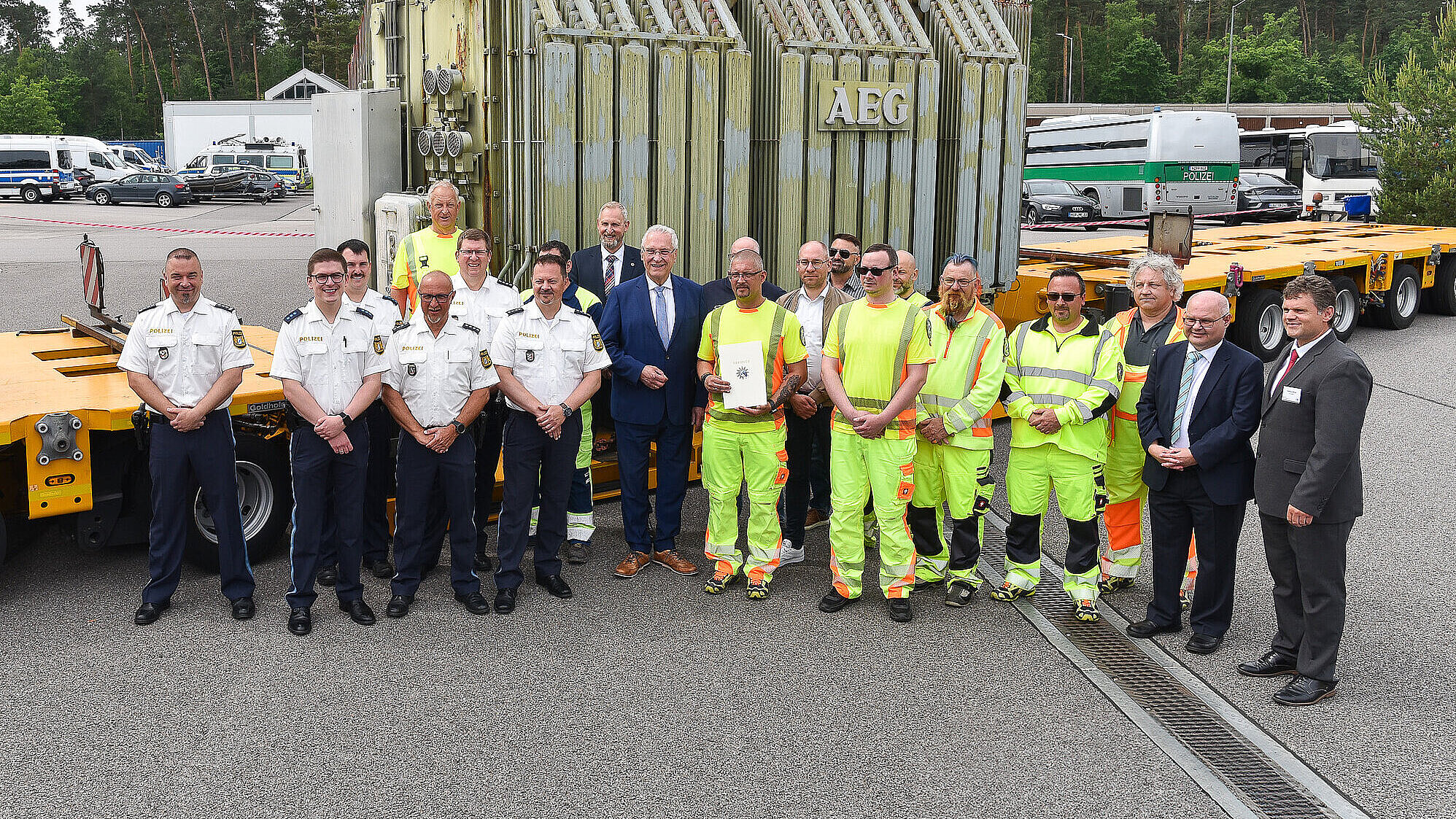 Innenminister Joachim Herrmann mit Polizisten und Transportbegleiter vor Transportfahrzeug