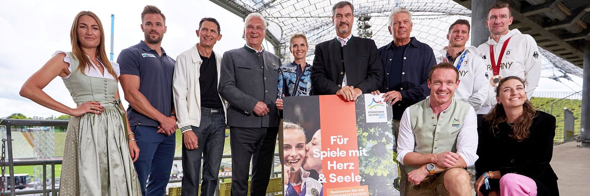 Auf dem Bild sind Ministerpräsident Dr. Markus Söder, Innenminister Joachim Herrmann, Oberbürgermeister Dieter Reiter und viele bekannte Athletinnen und Athleten im Olympiastadion München zu sehen, anlässlich der Olympia-PK am 2.9.2025.