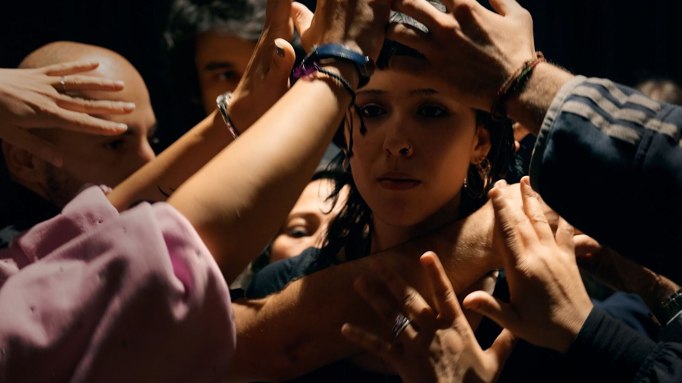 Tanzaufführung: Viele Hände legen sich über eine Frau