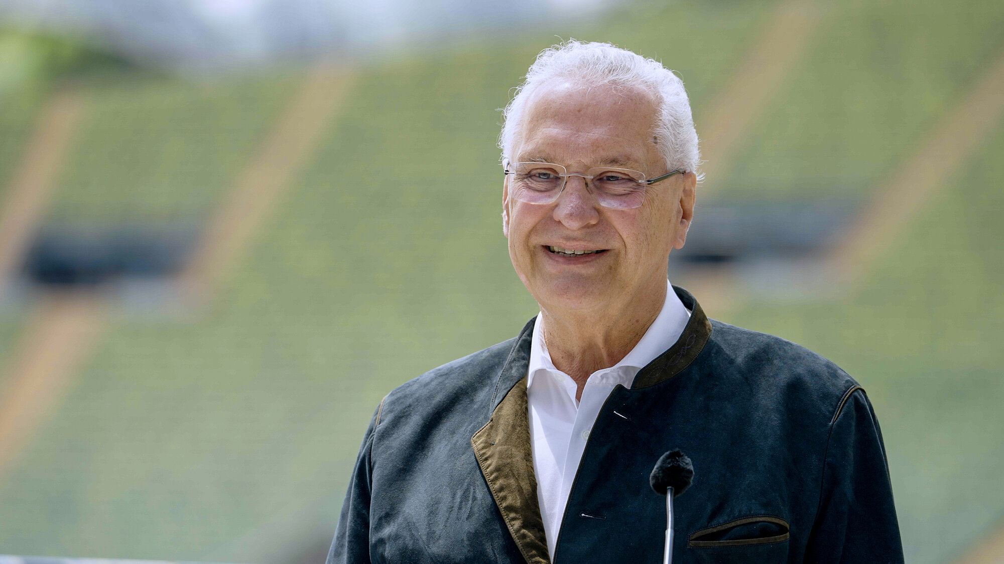 Portraitbild von Sportminister Joachim Herrmann mit Hintergrund vom Olympiastadion
